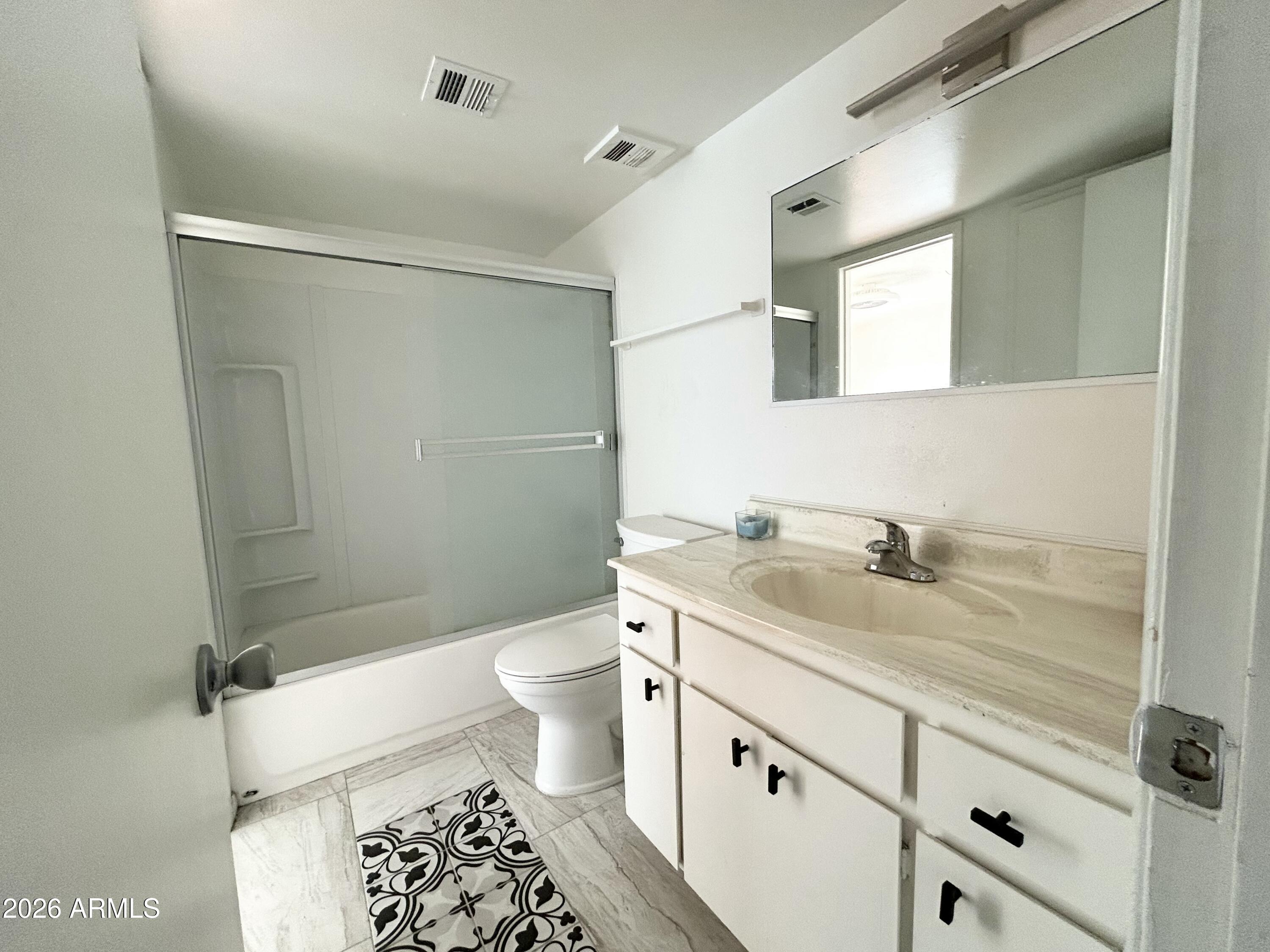 6565 North 19th Avenue, Unit 27 Phoenix, AZ 85015 - Photo 10 of 17 a bathroom with a granite countertop sink toilet and shower