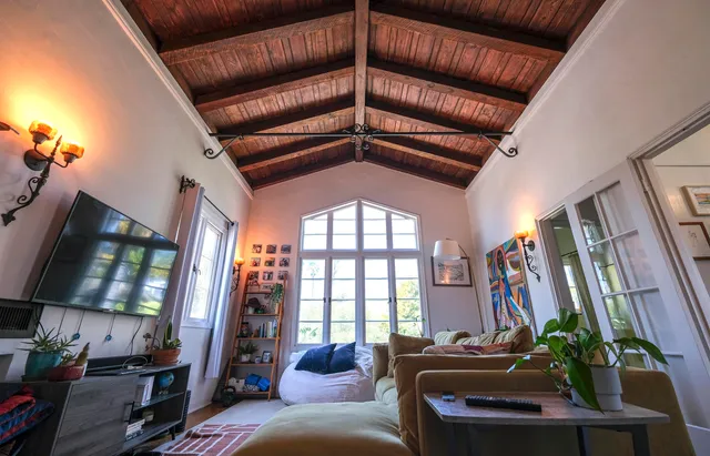 a living room with furniture a flat screen tv and a large window