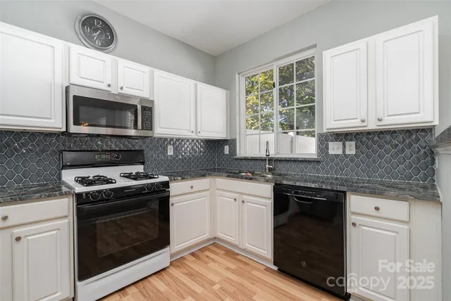 a kitchen with cabinets stainless steel appliances a sink and a stove