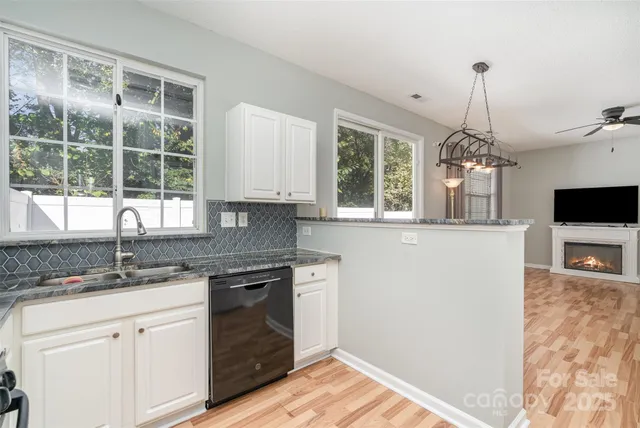 a kitchen with granite countertop a stove a sink and a chandelier