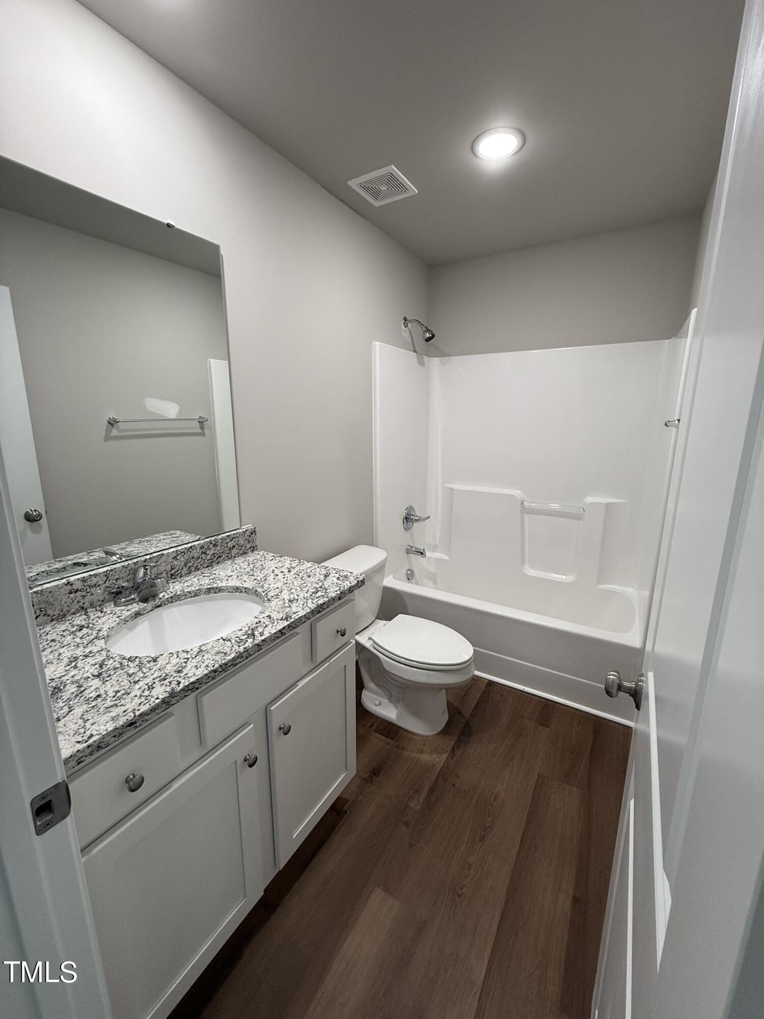 175 Grace Ridge Benson, NC 27504 - Photo 17 of 19 a bathroom with a granite countertop sink a toilet a large mirror and vanity