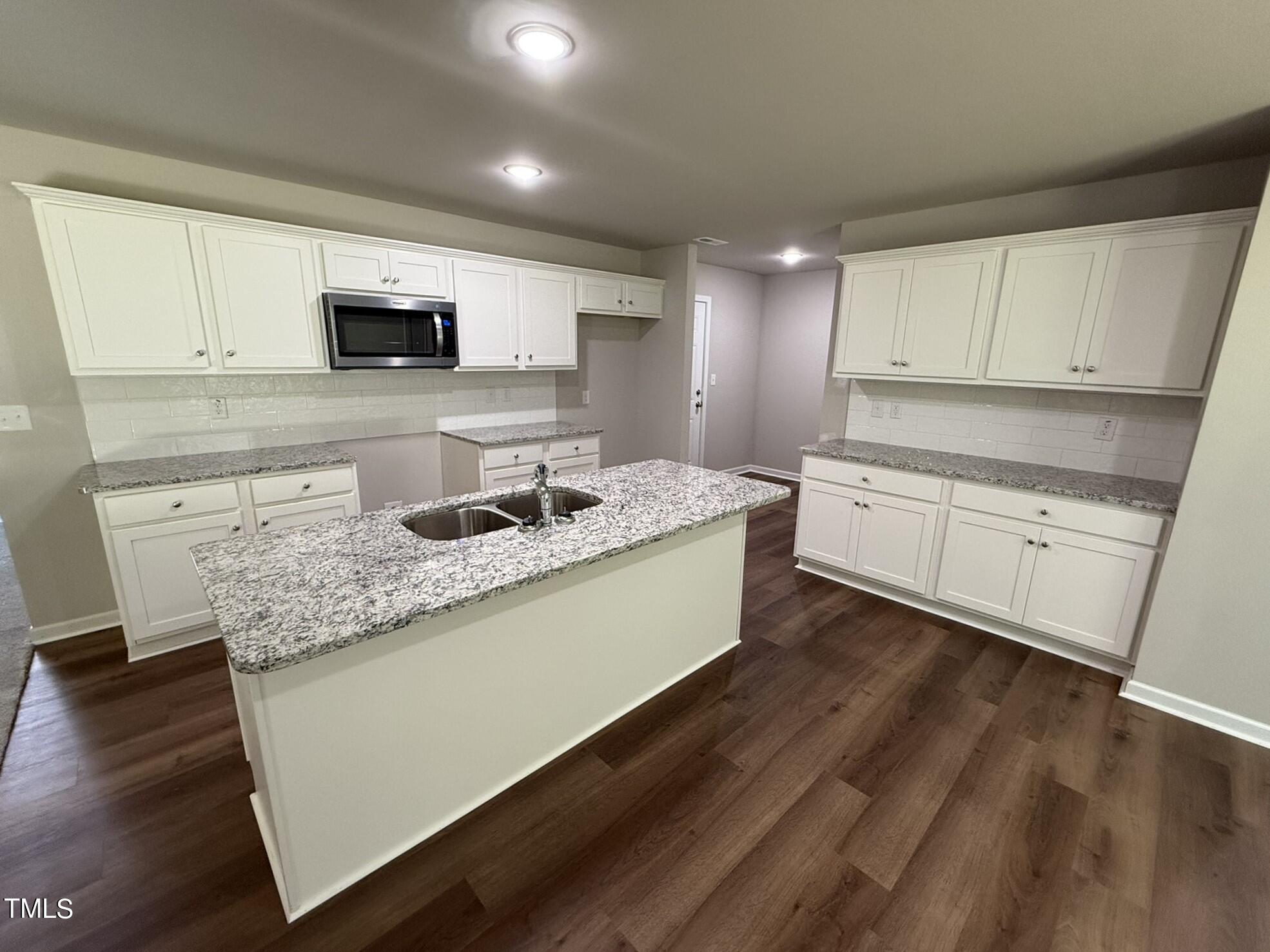 175 Grace Ridge Benson, NC 27504 - Photo 8 of 19 a kitchen with stainless steel appliances granite countertop a sink dishwasher a stove and white cabinets with wooden floor