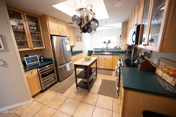 a view of a kitchen with fridge and workspace