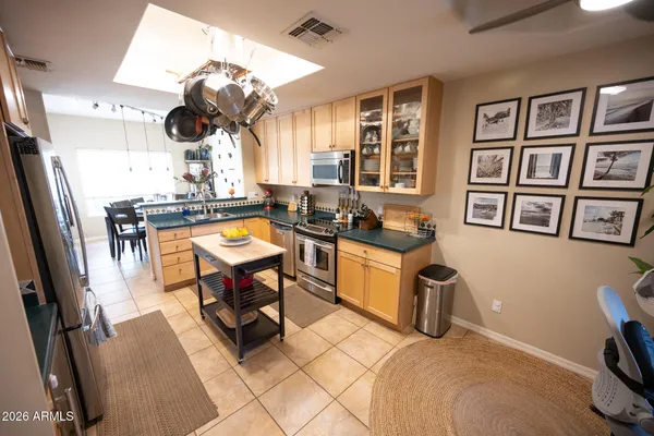 a bedroom with a bed a dresser and many windows