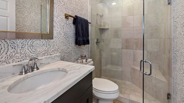 a bathroom with a granite countertop sink toilet and shower