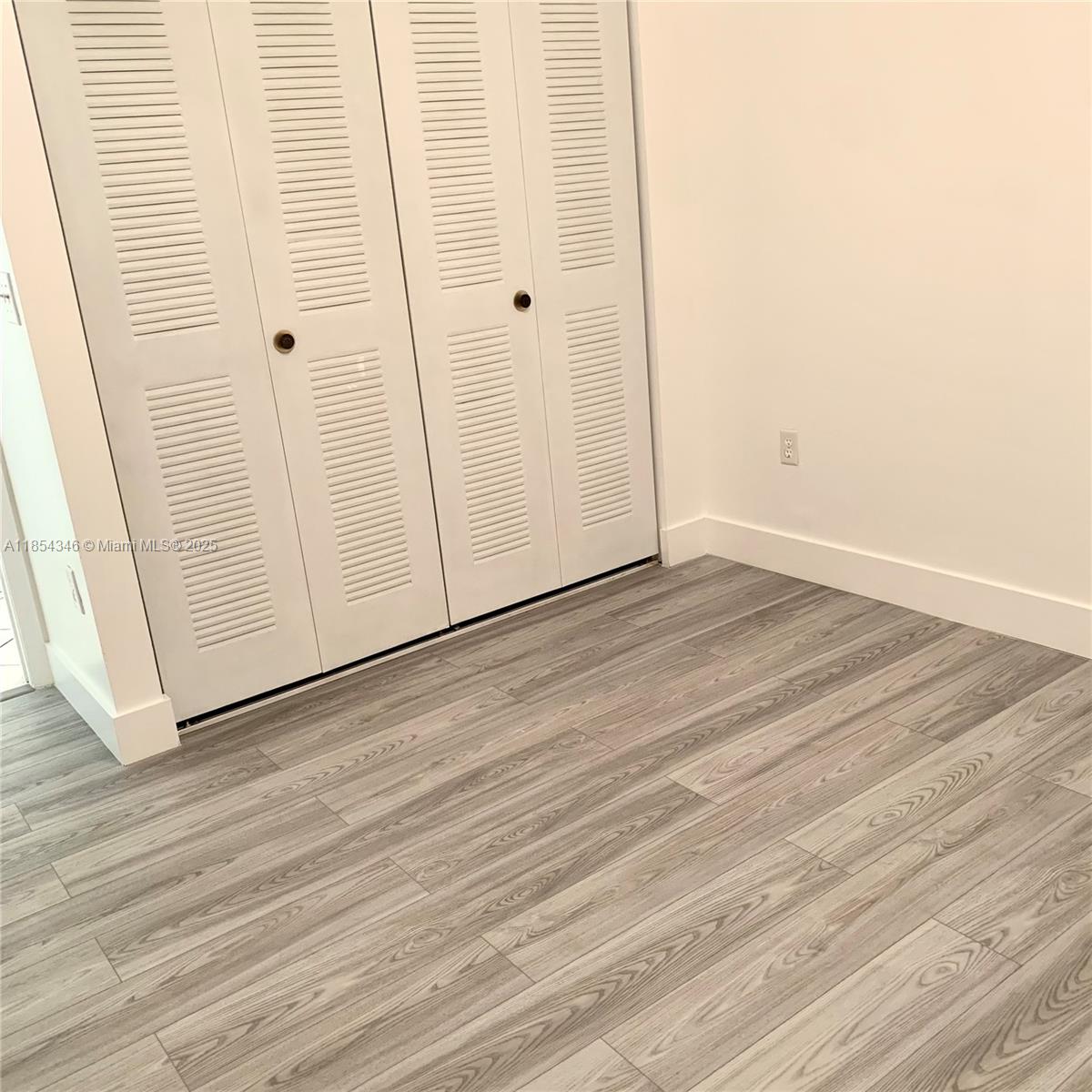 469 Northeast 207th Lane, Unit 207 Miami, FL 33179 - Photo 13 of 25 a view of a hallway with wooden floor