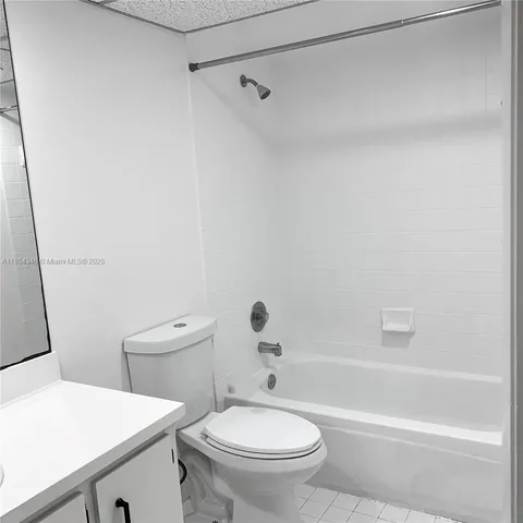 a white toilet sitting next to a bath tub