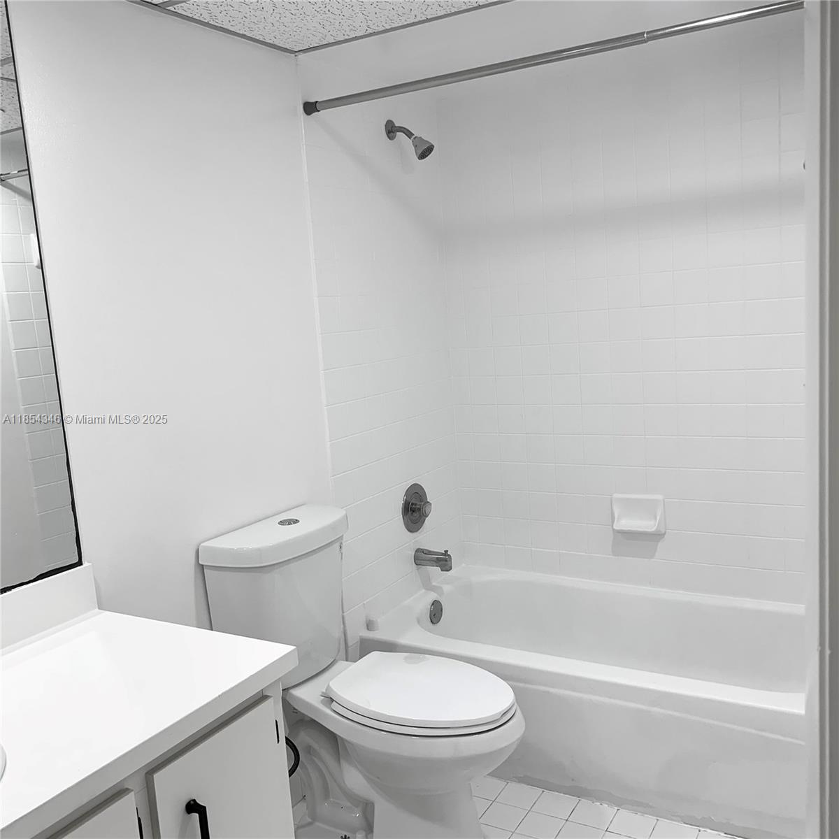 469 Northeast 207th Lane, Unit 207 Miami, FL 33179 - Photo 15 of 25 a white toilet sitting next to a bath tub
