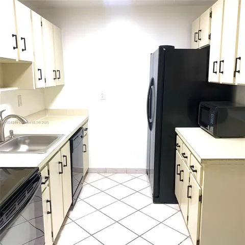 a kitchen with a refrigerator and a sink