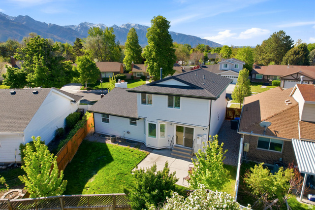 1405 Vintry Lane Murray, UT 84121 - Photo 41 of 44 Two-story residence featuring a dark shingled roof, light-colored siding, and a concrete patio