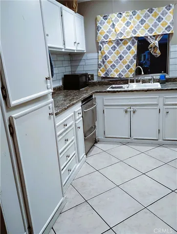 a kitchen with granite countertop white cabinets and white appliances