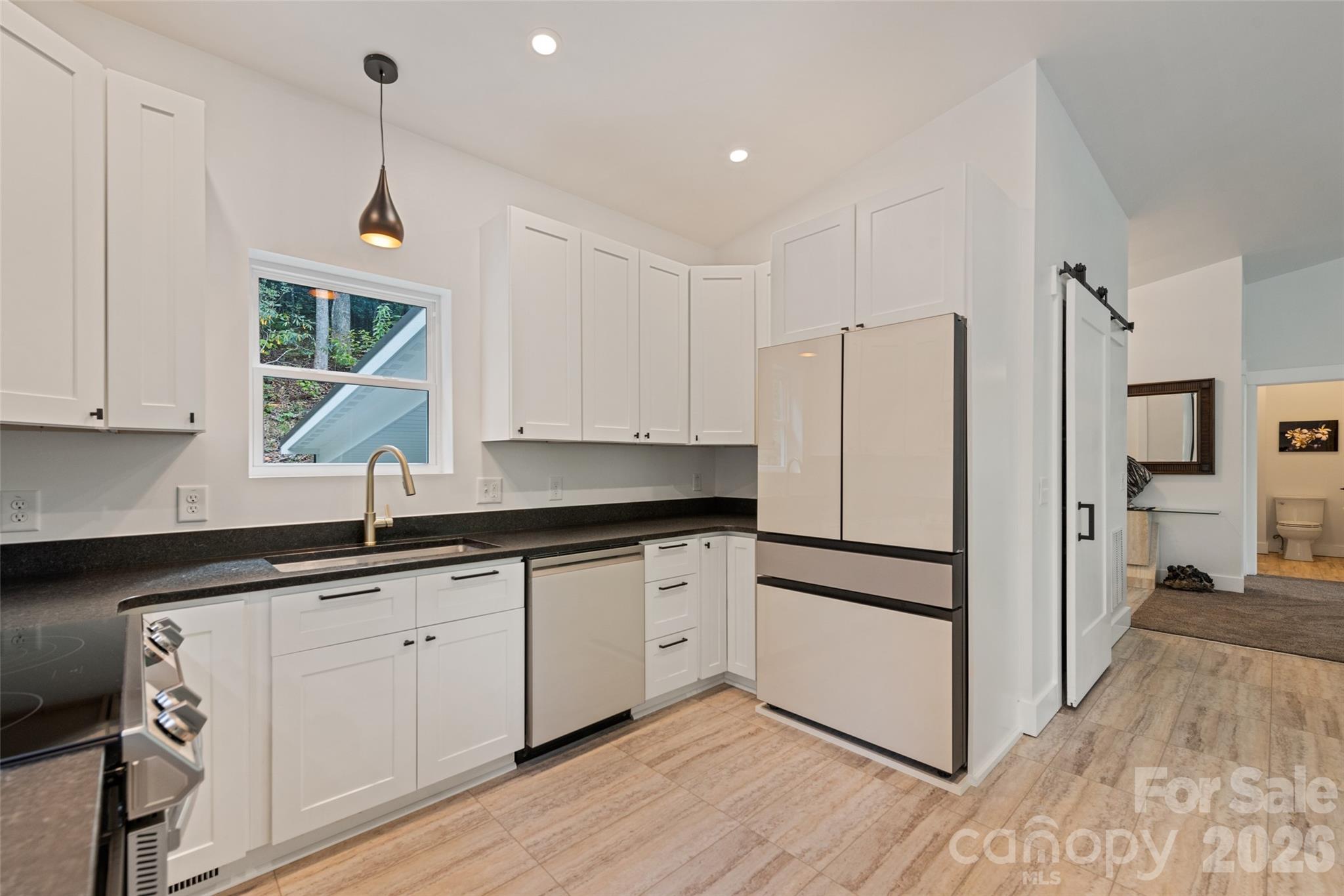 1185 Wallalieu Road Otto, NC 28763 - Photo 17 of 43 a kitchen with granite countertop white cabinets and white appliances