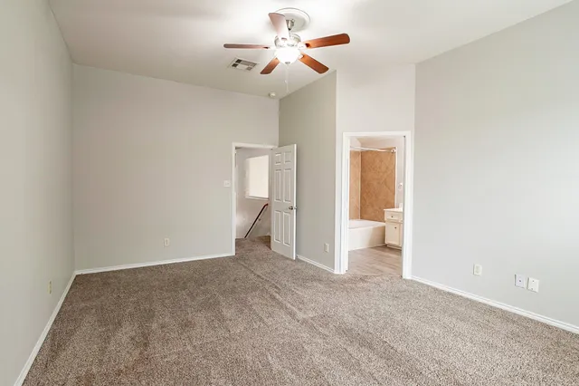 a view of an empty room and a ceiling fan window