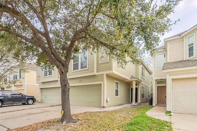a view of a house with a large tree