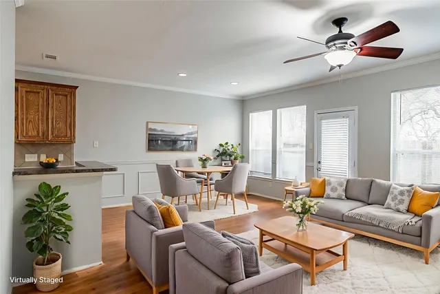 a living room with furniture a potted plant and a large window