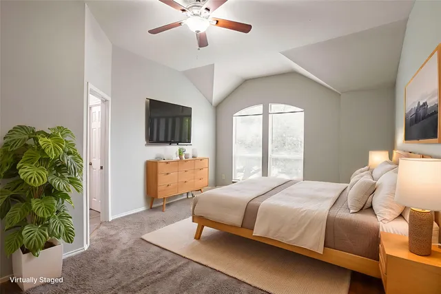 a bedroom with a bed and a flat tv screen on dresser