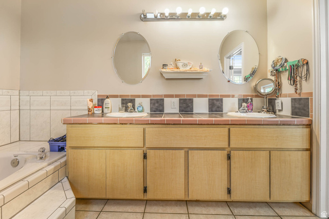 569 Elk Meadow Loop Tooele, UT 84074 - Photo 43 of 56 Bathroom featuring double vanity, a garden tub, and light tile patterned floors