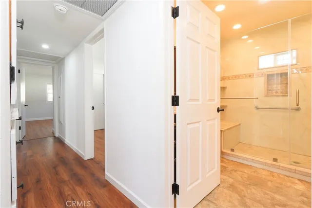 a view of a hallway with wooden floor and staircase