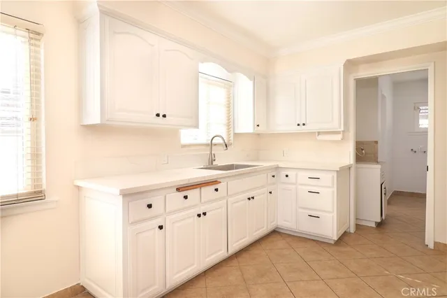 a kitchen with granite countertop white cabinets and sink