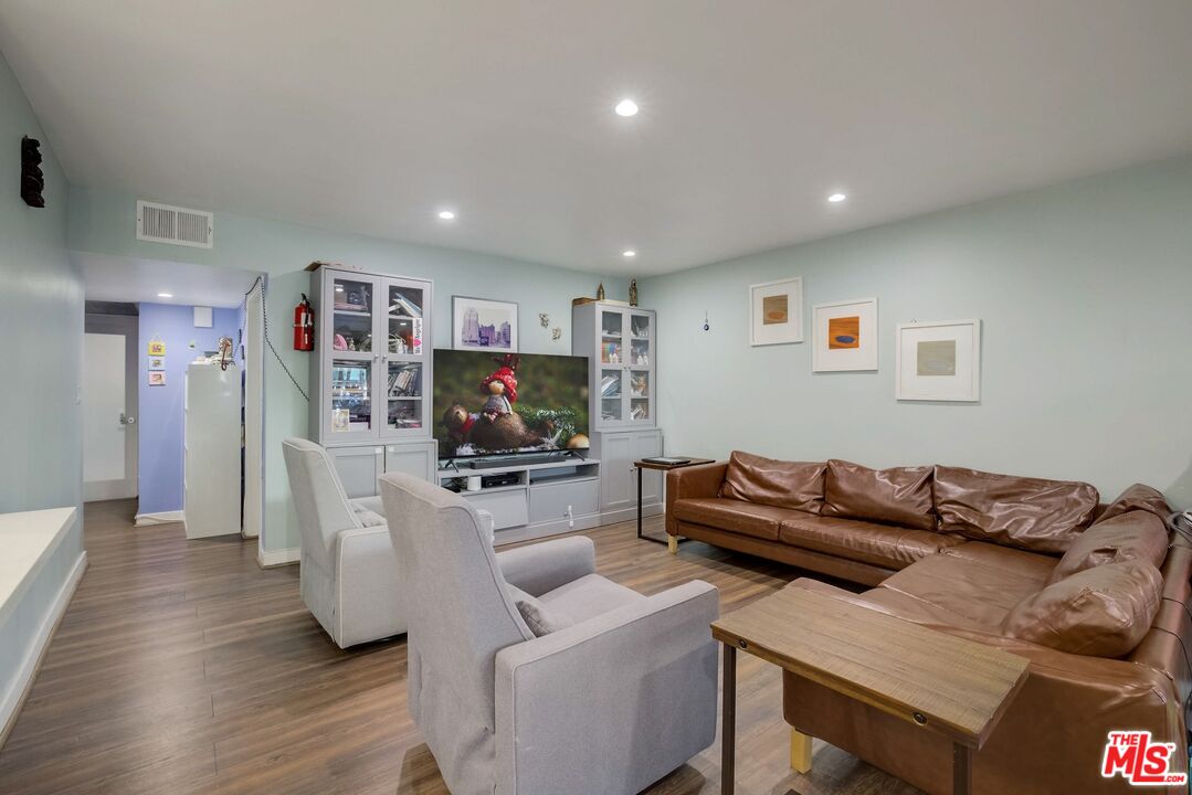 1045 North Kings Road, Unit 102 West Hollywood, CA 90069 - Photo 11 of 15 a living room with furniture and a flat screen tv