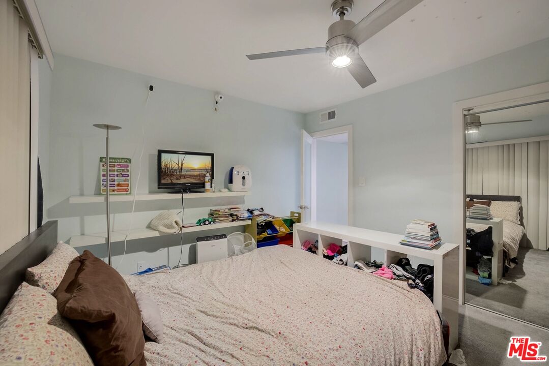 1045 North Kings Road, Unit 102 West Hollywood, CA 90069 - Photo 14 of 15 a bedroom with a bed and a flat tv screen on the dresser