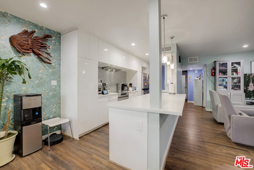 1045 North Kings Road, Unit 102 West Hollywood, CA 90069 - Photo 7 of 15 a view of a living room kitchen and a wooden floor