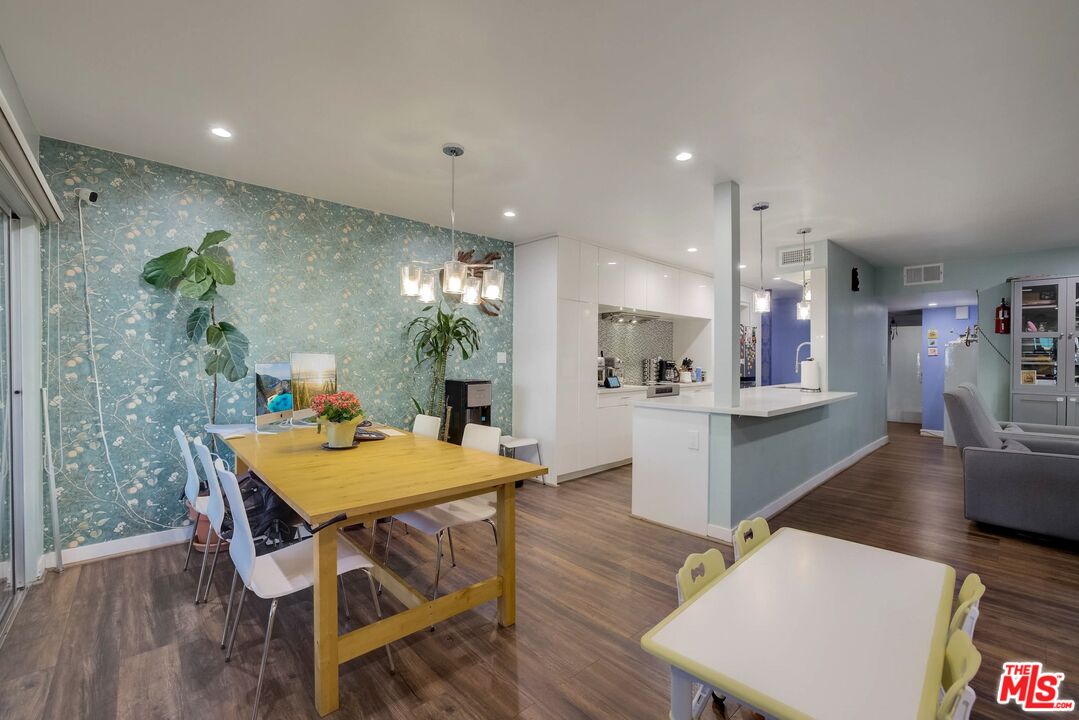 1045 North Kings Road, Unit 102 West Hollywood, CA 90069 - Photo 9 of 15 a view of a dining room with furniture and wooden floor