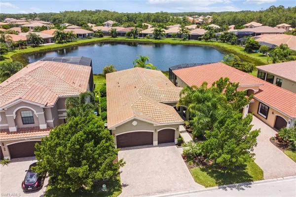 an aerial view of a house with outdoor space and lake view in back