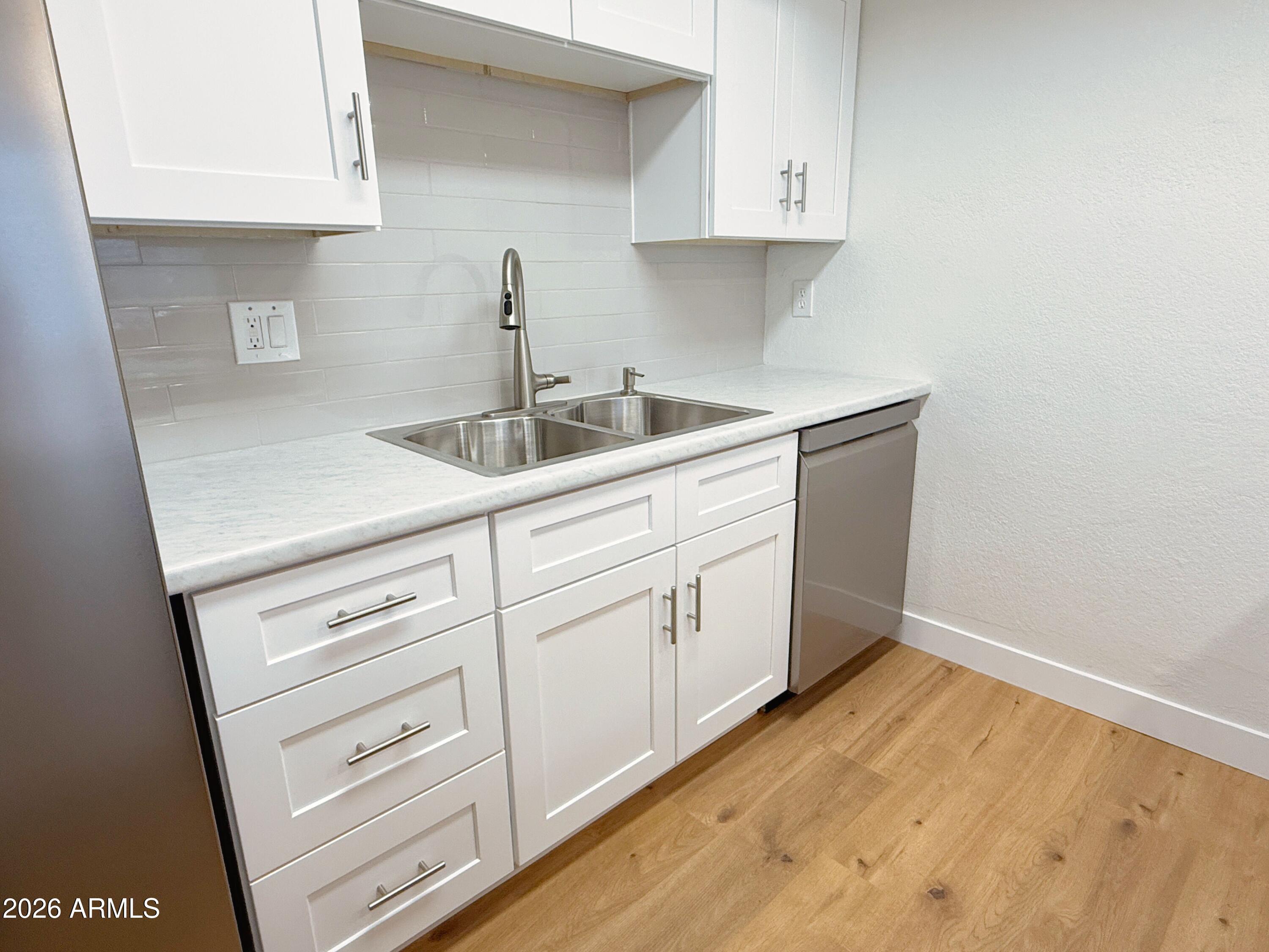 18202 North Cave Creek Road, Unit 148 Phoenix, AZ 85032 - Photo 8 of 19 a kitchen with white cabinets and sink
