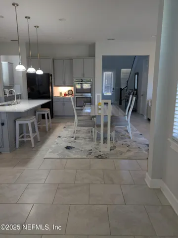 a kitchen with a sink a refrigerator and chandelier