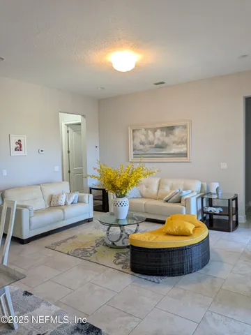 a living room with furniture and a floor to ceiling window