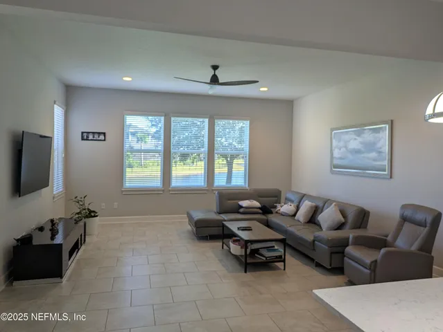 a living room with furniture and a floor to ceiling window