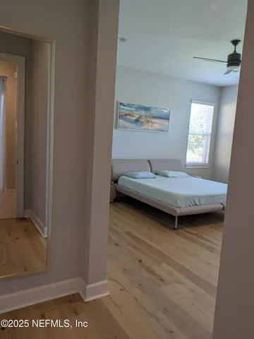 a bedroom with a bed and wooden floor