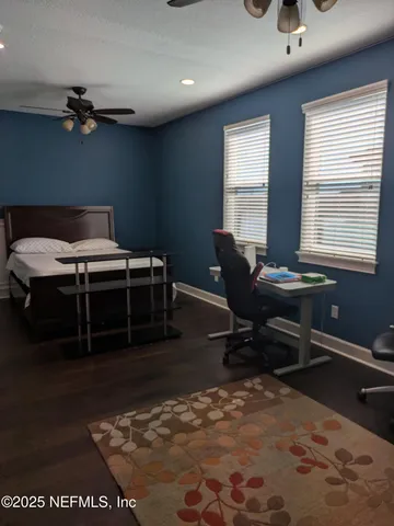 a view of a hallway with wooden floor and windows