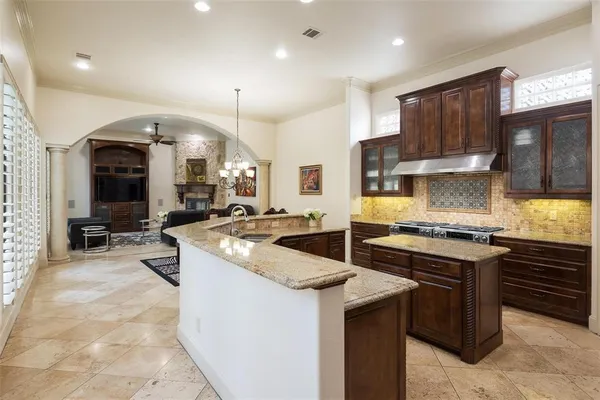 a kitchen with stainless steel appliances granite countertop a stove top oven a sink a stove and a refrigerator