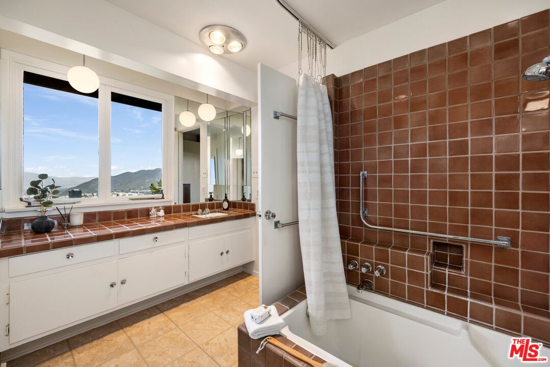 3230 Wrightwood Drive Studio City, CA 91604 - Photo 23 of 43 a bathroom with a double vanity sink a mirror and a bathtub