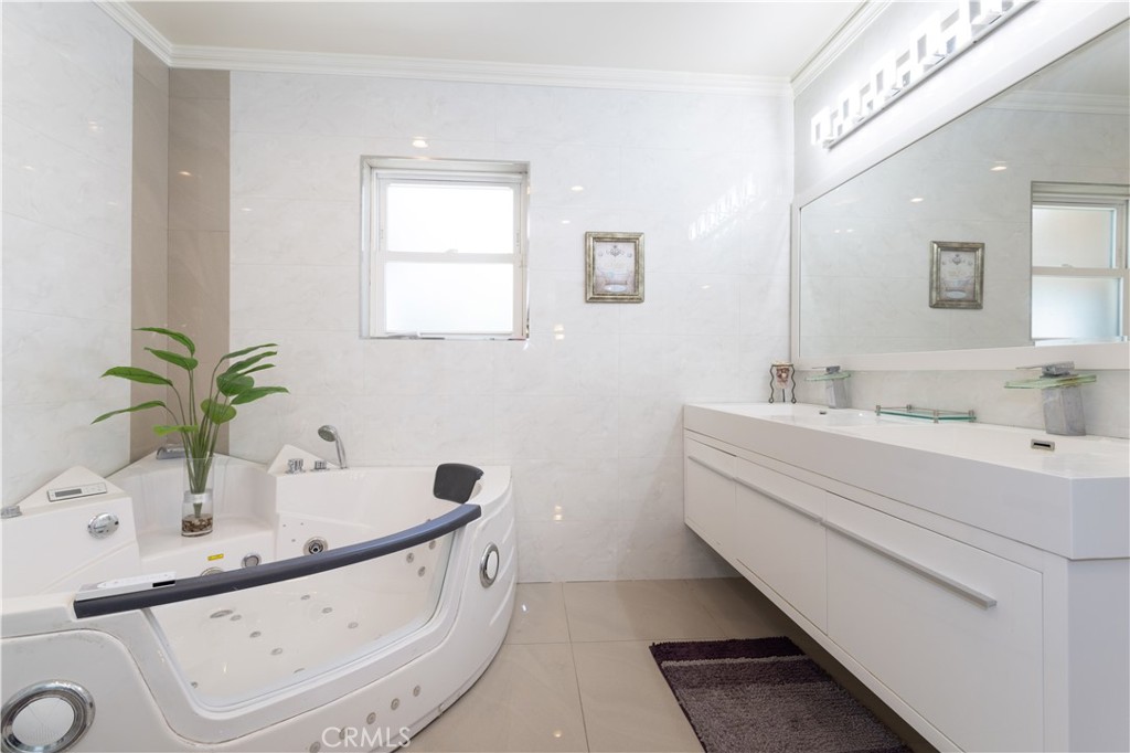 18308 Lahey Street Porter Ranch, CA 91326 - Photo 24 of 41 a bathroom with a tub sink and mirror