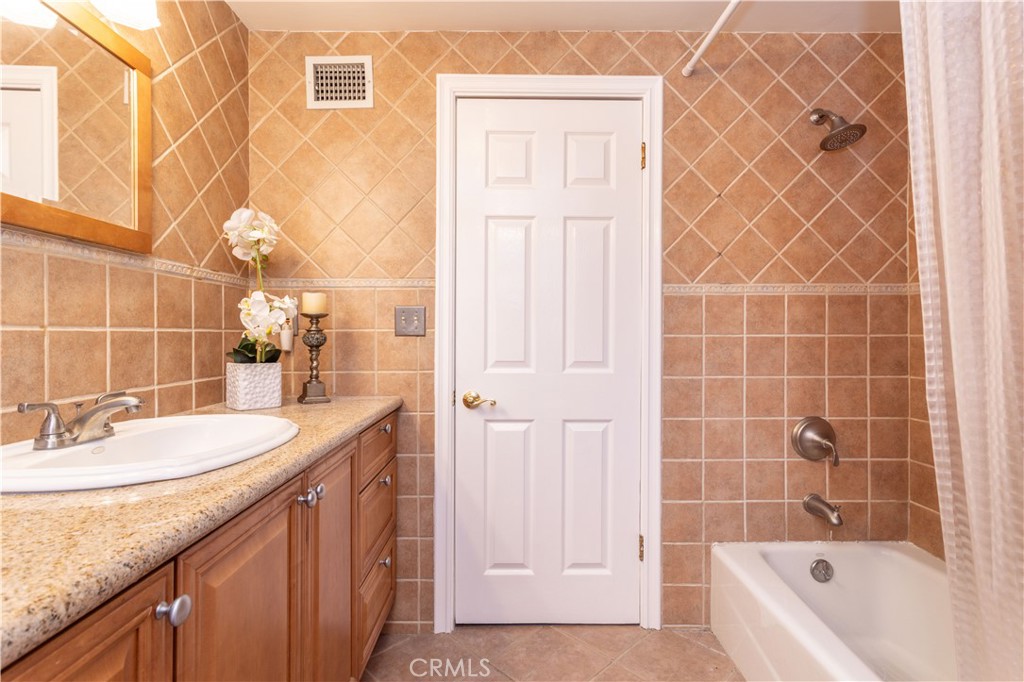 18308 Lahey Street Porter Ranch, CA 91326 - Photo 26 of 41 a bathroom with a granite countertop sink and a bathtub