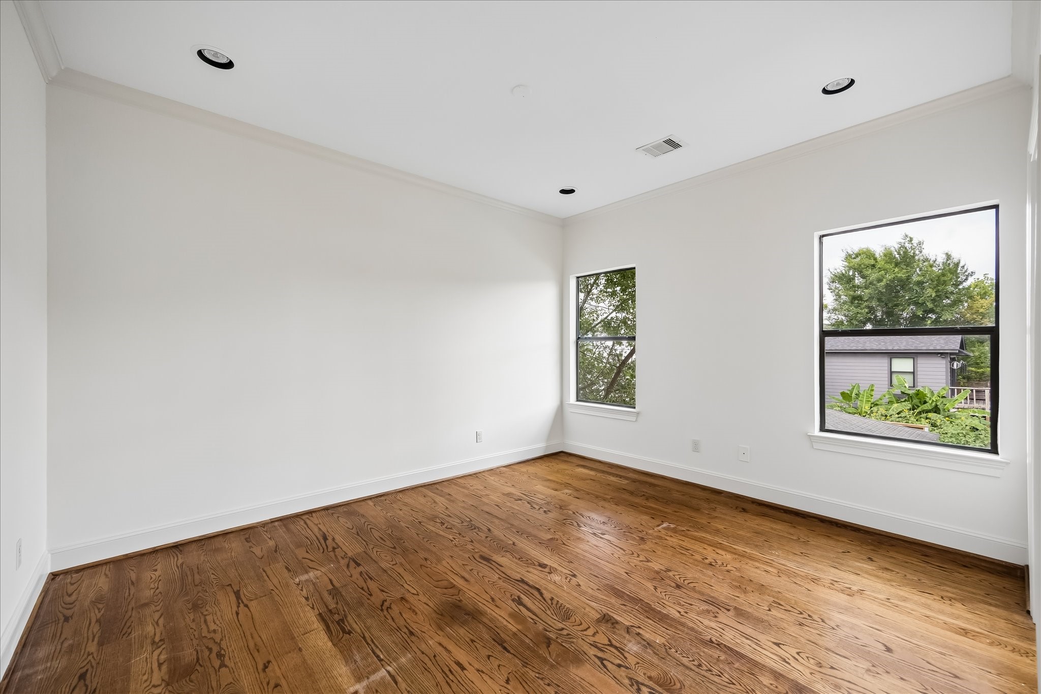 2246 Branard Street Houston, TX 77098 - Photo 31 of 40 Bright secondary bedroom with warm wood floors and a clean, versatile layout ready for a buyer’s personal touch.