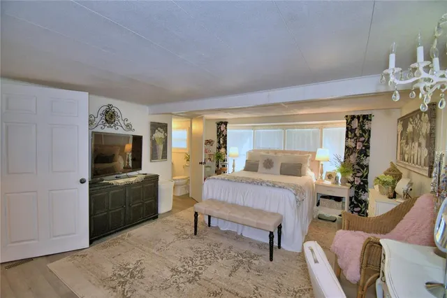 a bedroom with a large bed and a chandelier