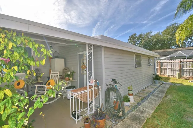 a view of a house with a big yard and palm trees