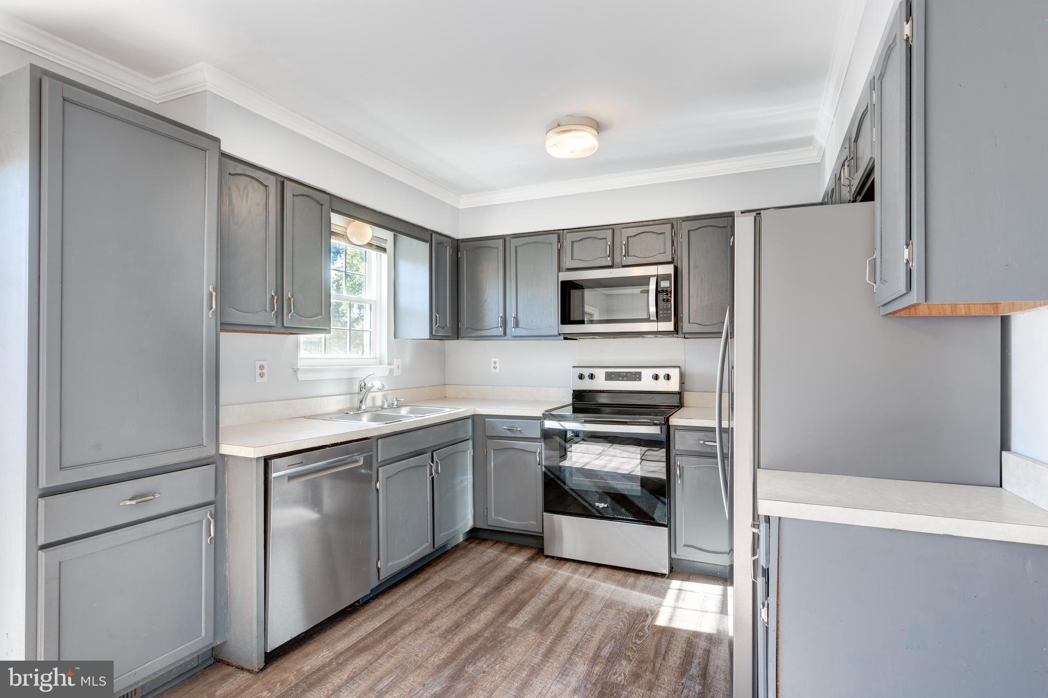 703 Uniontown Road Westminster, MD 21158 - Photo 5 of 42 a kitchen with stainless steel appliances a sink cabinets and wooden floor