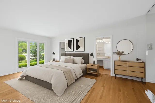 a bedroom with a large bed and wooden floor