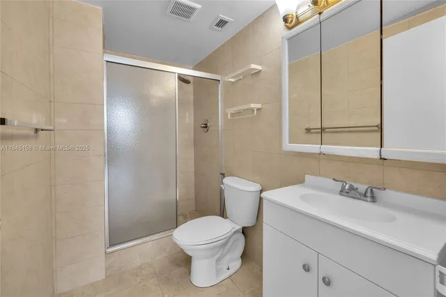 a bathroom with a toilet sink vanity and shower