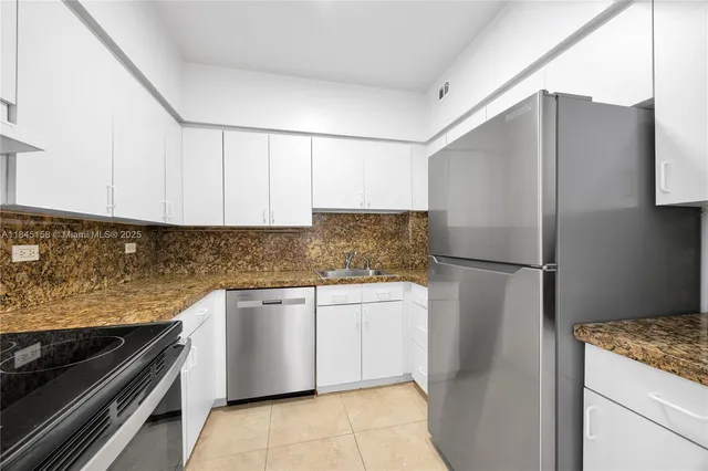 a kitchen with stainless steel appliances granite countertop a refrigerator and a stove