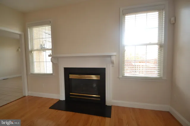 an empty room with windows and fireplace