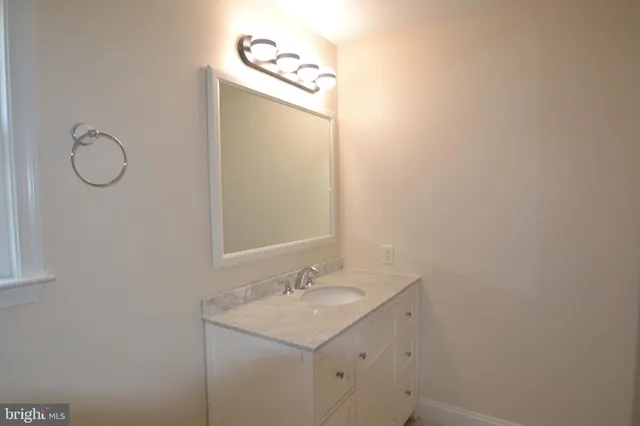 a bathroom with a granite countertop sink a toilet and mirror