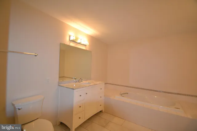 a bathroom with a granite countertop sink and a bathtub