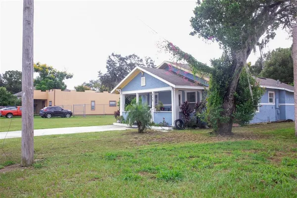a front view of a house with a yard and trees