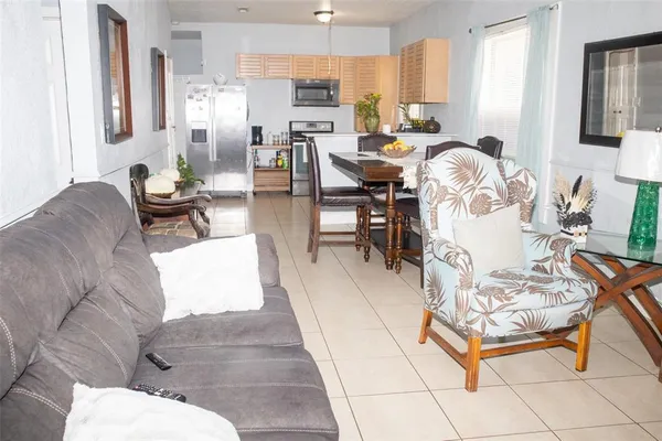 a living room with furniture a dining table and a chandelier